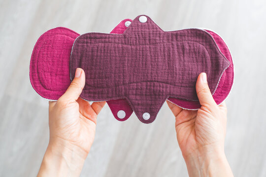 woman hands holding reusable cloth muslin menstrual pads in sustainable eco-friendly concept, promoting zero-waste alternatives for feminine hygiene products. Concept of sustainability and self-care