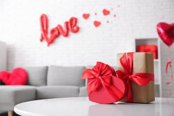 Table with gift boxes in stylish living room, closeup. Valentine's Day celebration