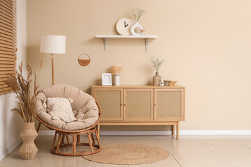 Armchair, chest of drawers and gypsophila flowers in vases in living room