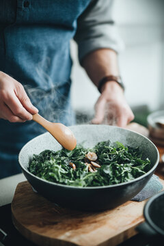 person cooking spinash dish