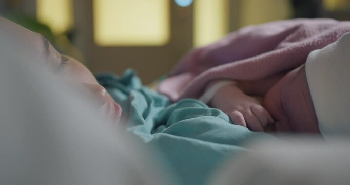 Mother nurses newborn baby placed on the chest directly after birth, close up 4k video footage
