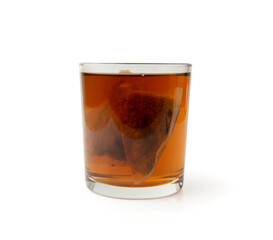 Herbal tea sachet in glass, hot water with chamomile and Hypericum or St. John's wort teabag
