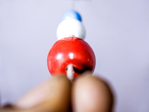 Hand holding Brock string for eye vision therapy exercise