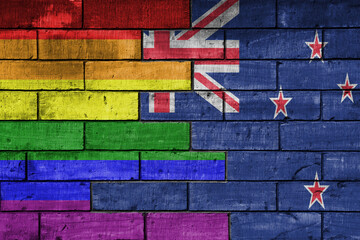 colourful painted big flag of new zealand and rainbow gay pride flag on a massive old brick wall...