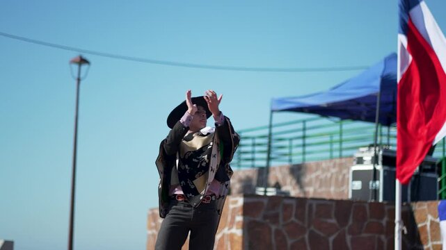 Traditional chilean couple dancers performing cueca steps in a sunny outdoor setting