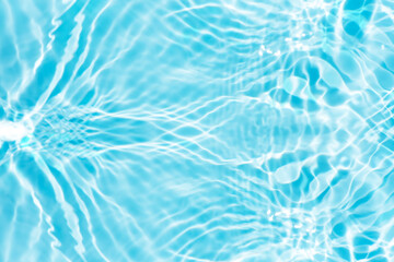 Blue water with ripples on the surface. Defocus blurred transparent blue colored clear calm water surface texture with splashes and bubbles. Water waves with shining pattern texture background.