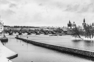 Snow blankets the historic Charles Bridge in Prague, enhancing the beauty of the Gothic...