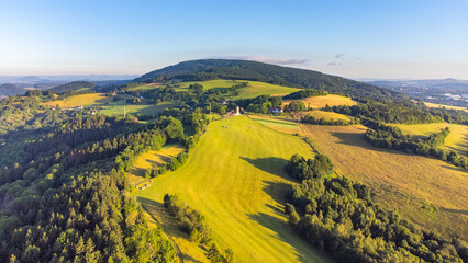 Green hilly landscape with green meadows and forests. Jested ridge near Liberec, Czechia. Aerial view from drone.