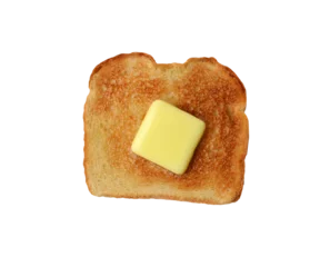 Overhead shot of a piece of buttered toast. A pat of melting butter is in the middle of the toasted white bread © Steve Cukrov