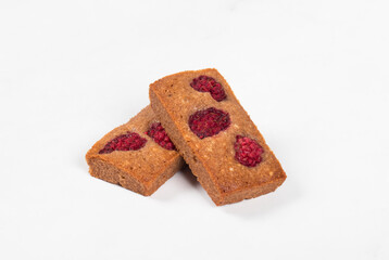 Financier. Chocolate almond cookies with raspberries. White background. Close up