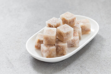Aspic. Jellied meat in the shape of a mini cubes. On a plate. Close up