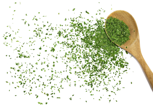 Chopped dry parsley leaves, pile in wooden spoon flying, isolated on white, clipping