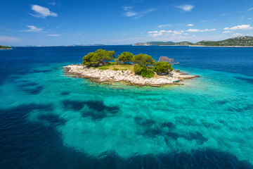 Fototapeta premium Aerial view of a small uninhabited island with crystal clear sea water
