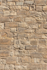 A beautiful texture of an old wall from orange stones with cracks. Vertical