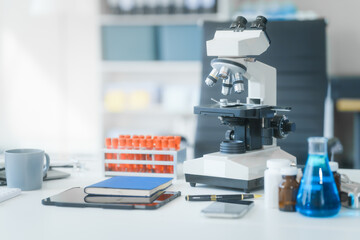 In an empty lab room with no people, a desk holds a blood tube, virus samples, and a monitor...