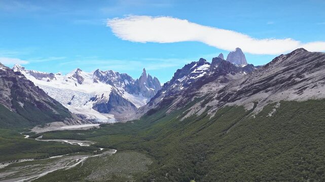 A Glimpse of Patagonia's Soul. The snow-covered peaks of FitzRoy tower above the valley floor, while the Rio de las Vueltas carves a sinuous path. A captivating display of nature's power and artistry.