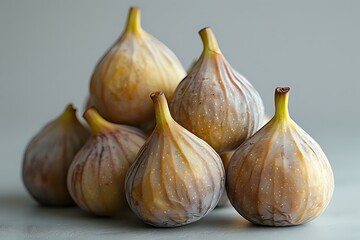 Obraz premium Fresh ripe figs arranged in artistic composition on light background, perfect for food photography, cookbook design, or culinary marketing materials.