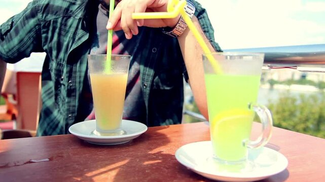 Young man drinking lemonade in cafe