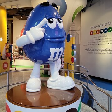 The M&M candy character inside M&M flagship store at Times Square, NYC, USA. M&M's are color-varied sugar-coated drag&eacute;e chocolate confectionery, each has letter "m" on it. Photo by Artist Nadia Russ. 