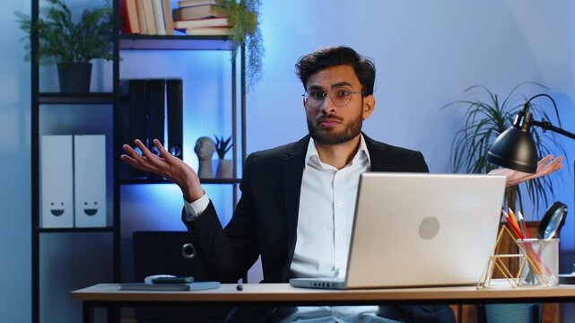 I don't know what to say. Confused business man working on laptop at office workplace. Freelancer feeling embarrassed about ambiguous question, having doubts, no answer idea, being clueless, uncertain