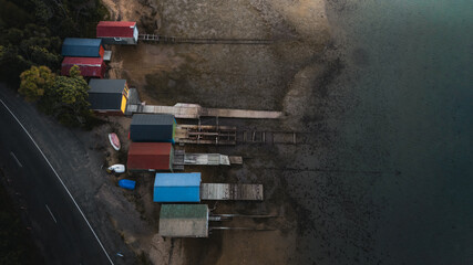 Obraz premium A top down drone shot of colorful fishing huts on the edge of the sea shore