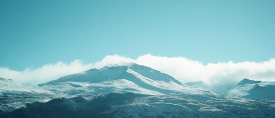 Snow-capped mountains blend with gentle clouds under a clear, blue sky, evoking a serene and majestic winter landscape.
