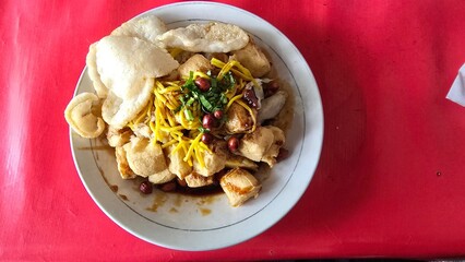 Plate of tahu kupat or fried tofu served with rice cake and soy sauce