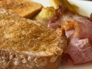 close up of french toast with toast, bacon and caramelized bananas.