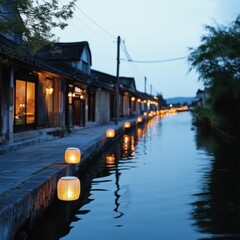 Obraz premium Tranquil Evening by the River with Lanterns and Traditional Architecture