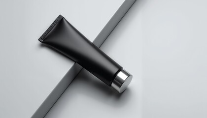 Black matte cosmetic tube on gray minimalistic surface