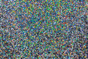 Full frame macro abstract texture background of a sparkling multi color confetti glitter surface
