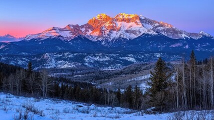 Majestic sunrise illuminates snow-capped mountain range.