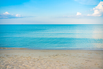 The beach and sea surface with Deep Blue sea clear sky clouds. Landscape with Ocean small waves water reflection copy space for text. Illustration for tourism, website or ad. Andaman sea, Thailand.