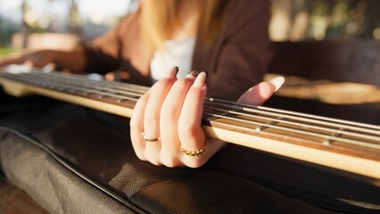 Girl Plays The Bass Sitting At The Table In A Natural Park