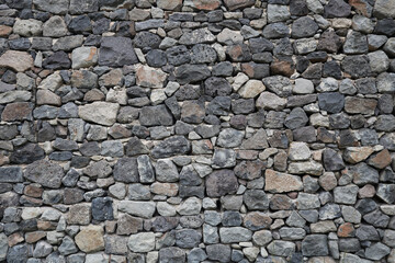 Old historical stone wall background texture close up. Texture pattern of a stone wall. aged castle stone wall texture background. Stone wall as a background or texture. Part of stone wall backdrop.
