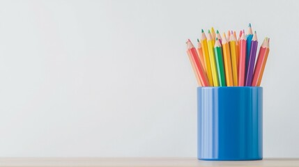 A blue container filled with colorful pencils against a plain background.