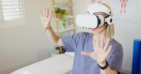 Using VR headset, woman in scrubs exploring virtual environment in medical clinic, copy space - Powered by Adobe