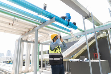 Male engineer using virtual reality headset at construction site. Male plumber wearing virtual...
