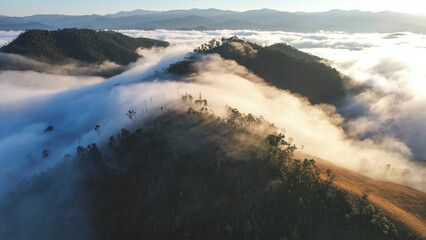 Aerial landscape view of the sea of fog flowing on hills by drone