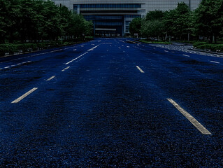 Obraz premium Empty Asphalt Road Leads to Modern Building Between Lush Green Trees in a Tranquil Setting.