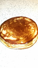 Stack of Pancakes Drizzled with Syrup on a Speckled Countertop