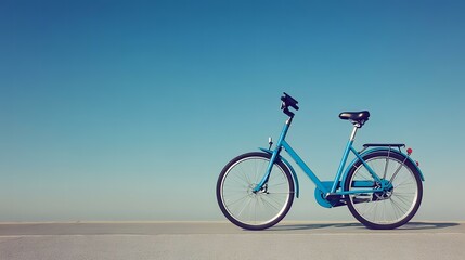 Fototapeta premium Blue bicycle on coastal path, clear sky, summer day, travel
