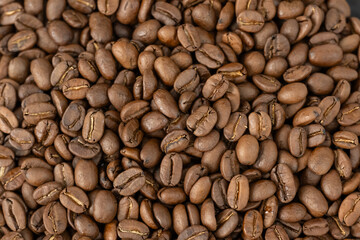 Close-up of roasted arabica coffee beans.Heap of coffee beans stacked  prepare making menu in the cafe by machine ready to be brewed into a delicious cup.Textured background.