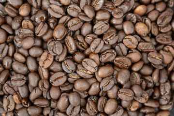 Close-up of roasted arabica coffee beans.Heap of coffee beans stacked  prepare making menu in the cafe by machine ready to be brewed into a delicious cup.Textured background.