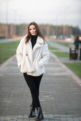 Obraz premium Beautiful young dark-haired girl in an urban environment in early spring.