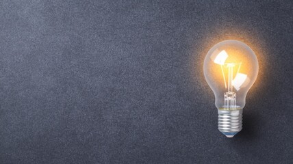 A glowing light bulb against a dark background, symbolizing ideas, innovation, and creativity.