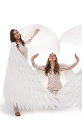 Elegant dancers portraying angelic figures in creative performance costume