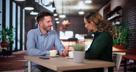 Laughing Male And Female Sitting In Cafe Drinking Coffee