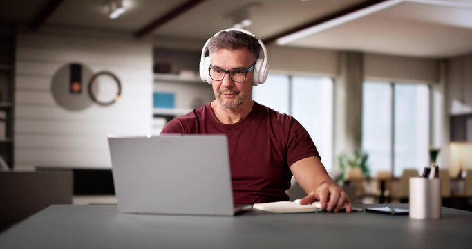 College Teacher At Home Using Laptop