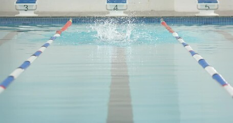Swimmer performing butterfly stroke in swimming pool, focusing on technique, copy space